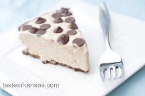This photo shows a picture of no bake peanut butter pie. The pie is light and fluffy, on a chocolate cookie crust with milk chocolate chips dotting the top of the pie.