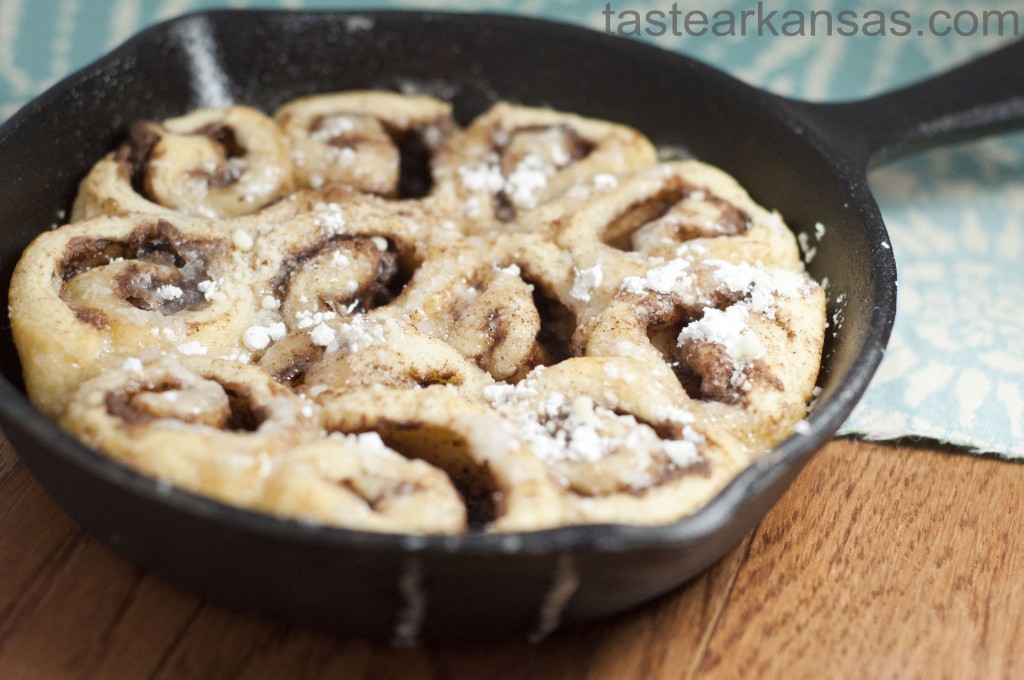 this image shows a cast iron skillet full of nutella cinnamon rolls