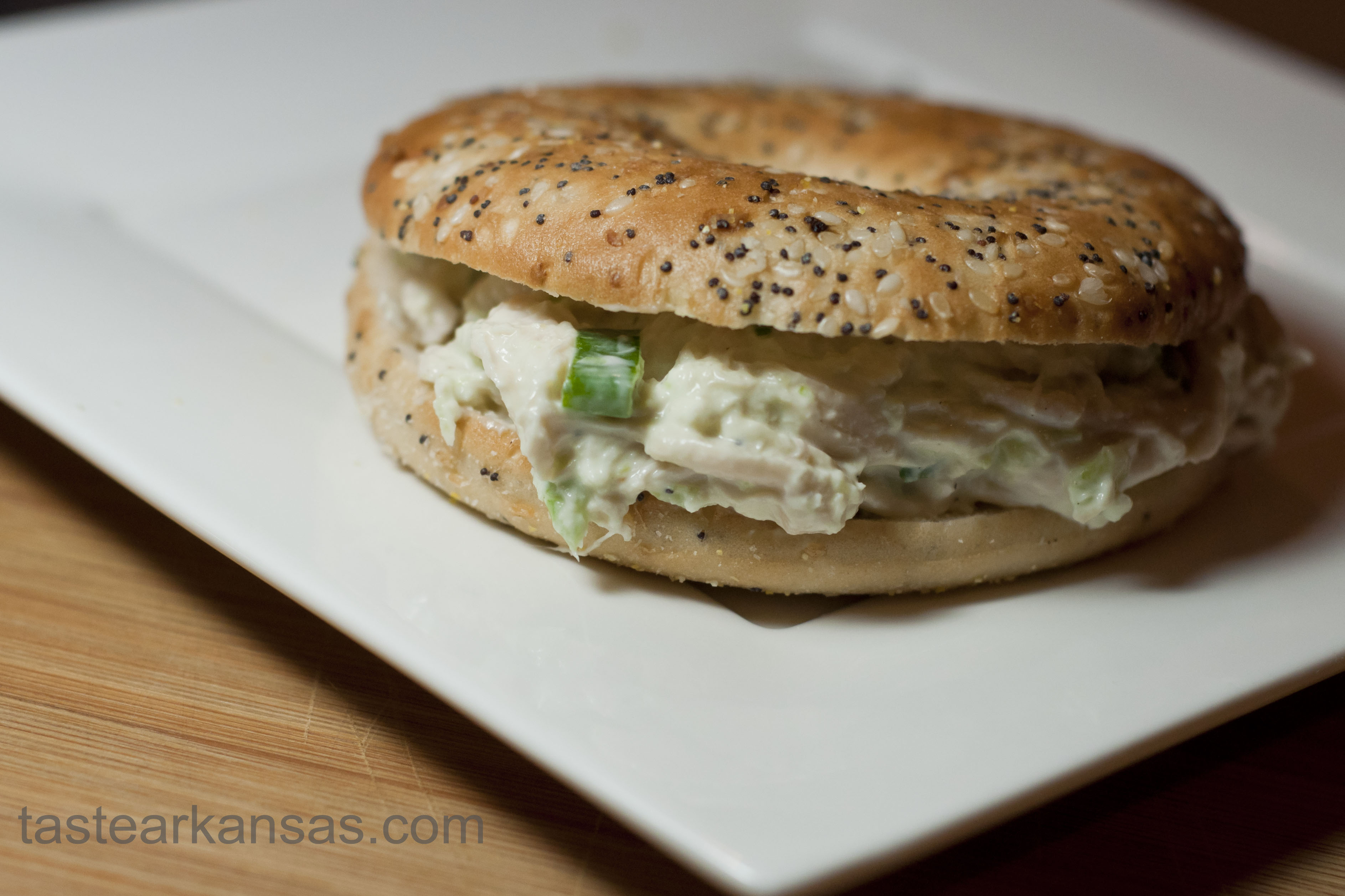 this image is of a creamy chicken salad sandwich on a bagel thin